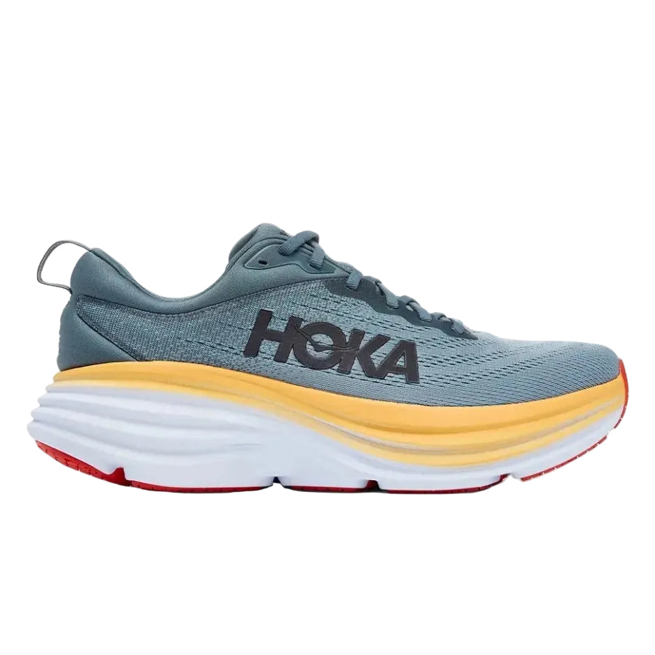 A HOKA running shoe in slate blue-gray with a thick white midsole, a yellow-orange accent band, and a red outsole, shown in a side profile on a white background.