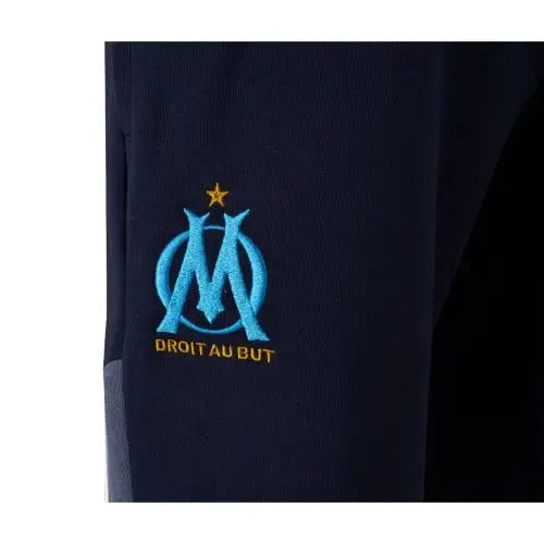 Embroidered logo on a dark blue fabric with text 'Droit au But'.