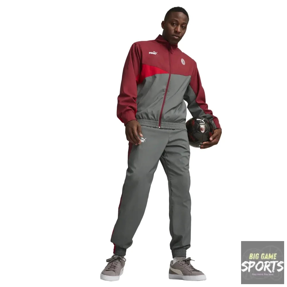 A male model wearing a Puma track suit in maroon and gray, holding a soccer ball against a light gray studio background.