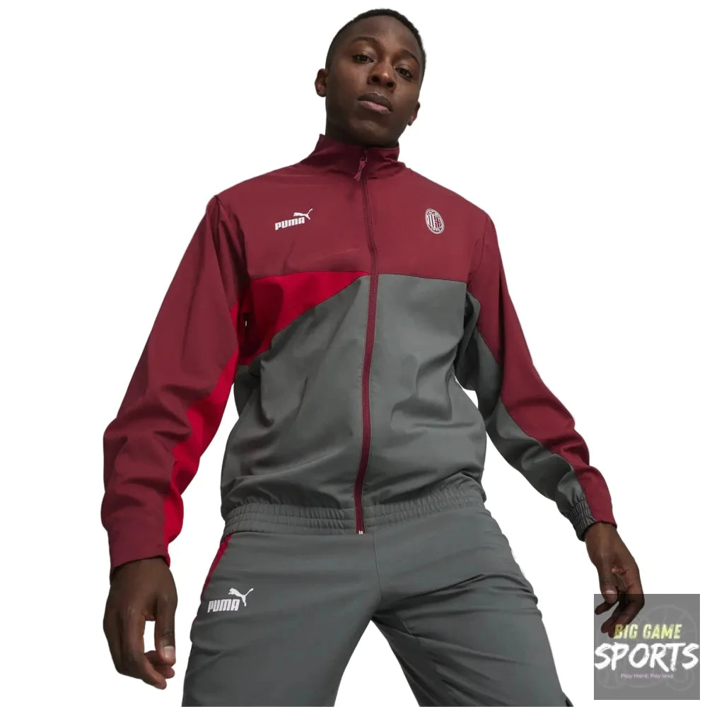 A male model wearing a Puma track jacket and matching track pants in maroon and gray, standing against a light gray studio background.