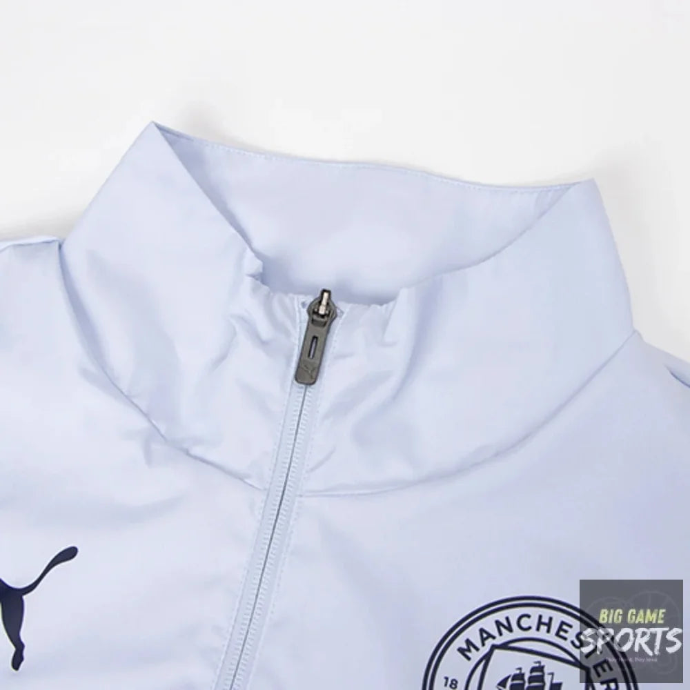 Close-up of a light blue Puma Manchester City zip-up jacket, showing the collar, zipper, Puma logo, and Manchester City crest.