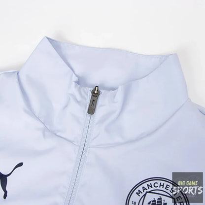 Close-up of a light blue Puma Manchester City zip-up jacket, showing the collar, zipper, Puma logo, and Manchester City crest.