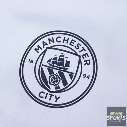 Close-up of a Manchester City crest printed in dark navy on a white fabric surface.