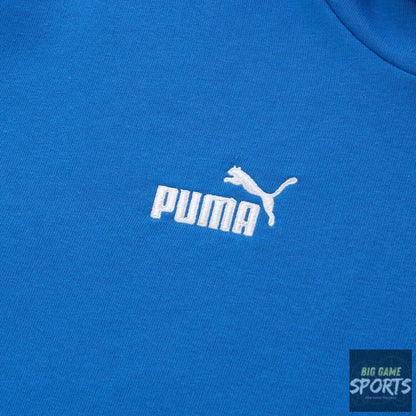 A close-up of a bright blue Puma sweatshirt showing the white embroidered Puma logo and leaping cat emblem on the chest.