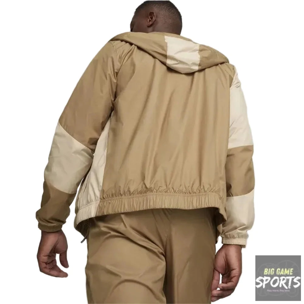 Person wearing a beige and brown jacket with a plain background