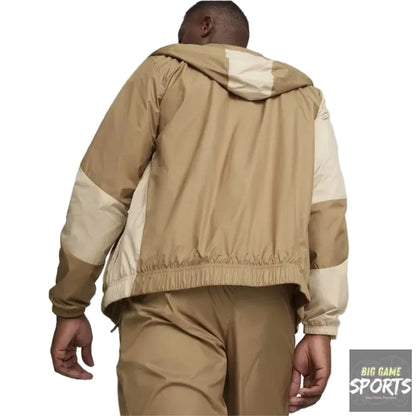 Person wearing a beige and brown jacket with a plain background