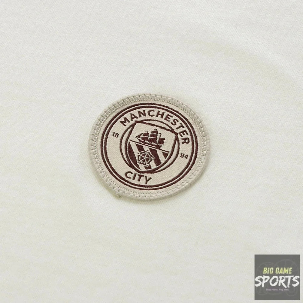 A circular Manchester City embroidered patch on a white fabric background.