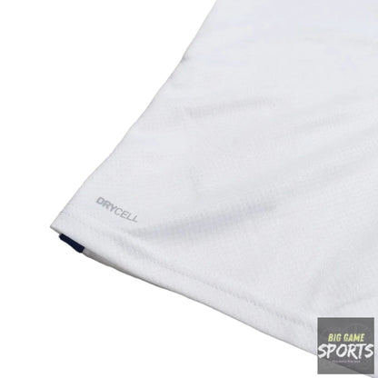 Close-up of a white athletic fabric corner with a small gray 'DRYCELL' logo and a tiny dark blue tag, shown on a light gray background.