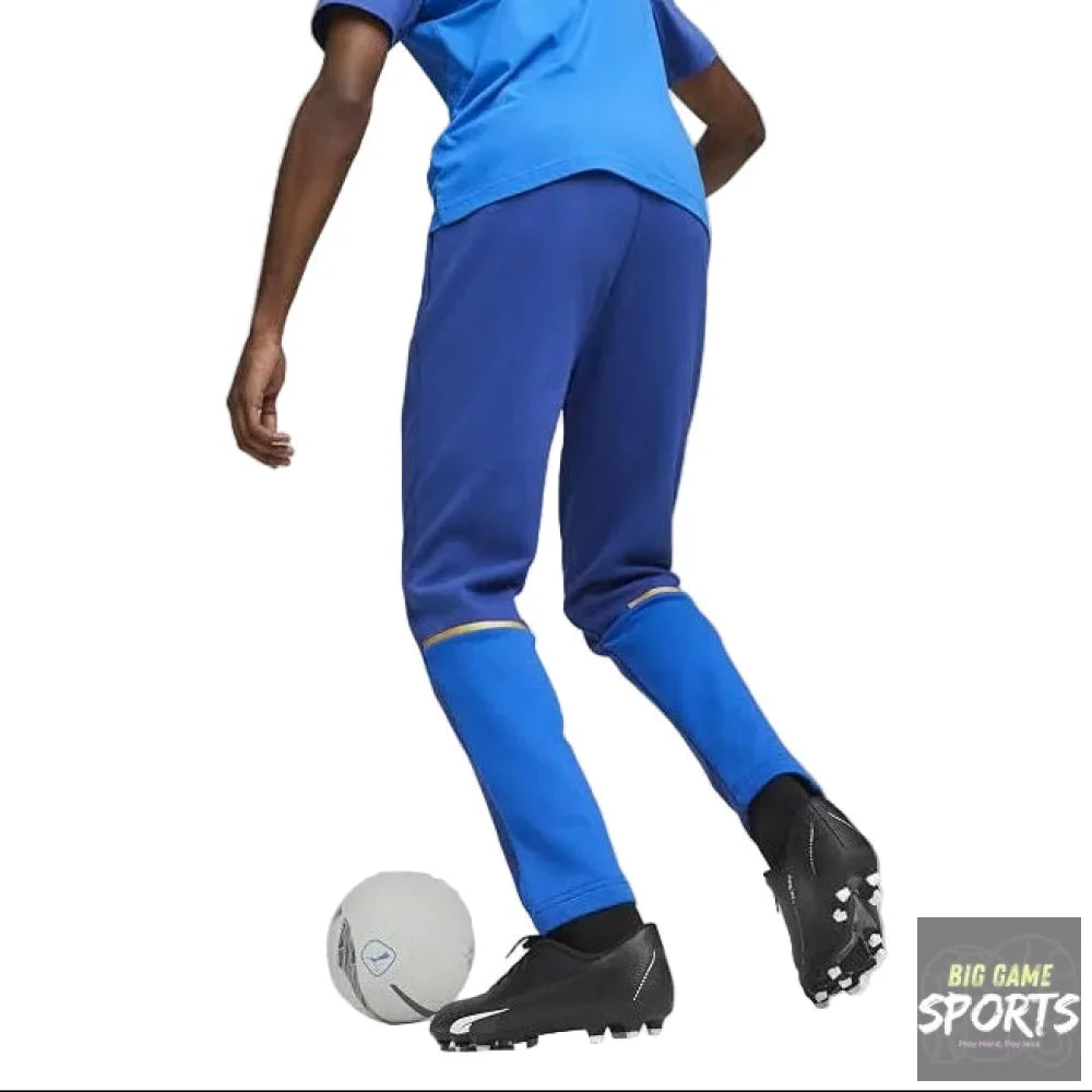 Person wearing blue soccer pants and black cleats with a soccer ball on a gray background