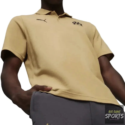 Person wearing a beige polo shirt and dark gray shorts with logos on a white background