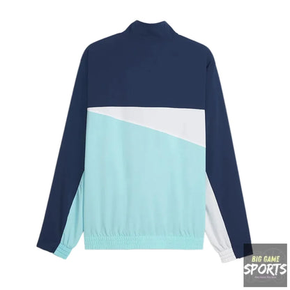 A long-sleeve colorblock jacket shown from the back, featuring a navy blue upper section and sleeves, a diagonal light blue lower section, and a white diagonal stripe separating them.